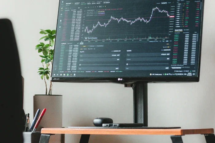 Desktop monitor on a desk with investing graphs