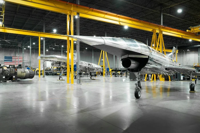 a jet sitting inside a hangar next to other planes