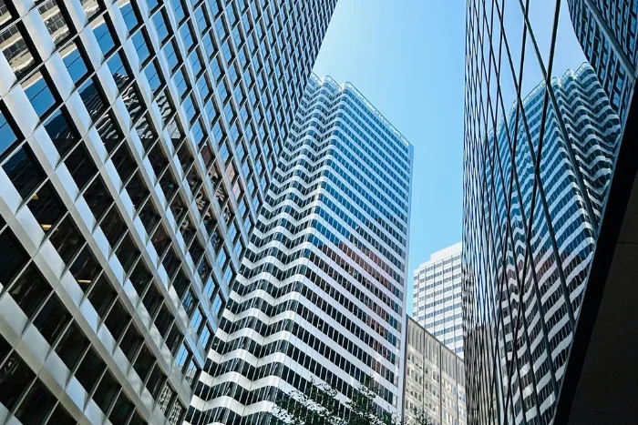 skyscrapers reach high into a bright blue sky